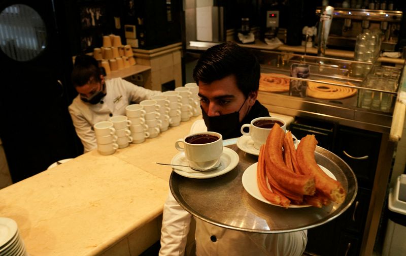 &copy; Reuters. FILE PHOTO: A masked waiter carries hot chocolate and churros at a bar in Madrid, Spain, January 25, 2022. REUTERS/Vincent West