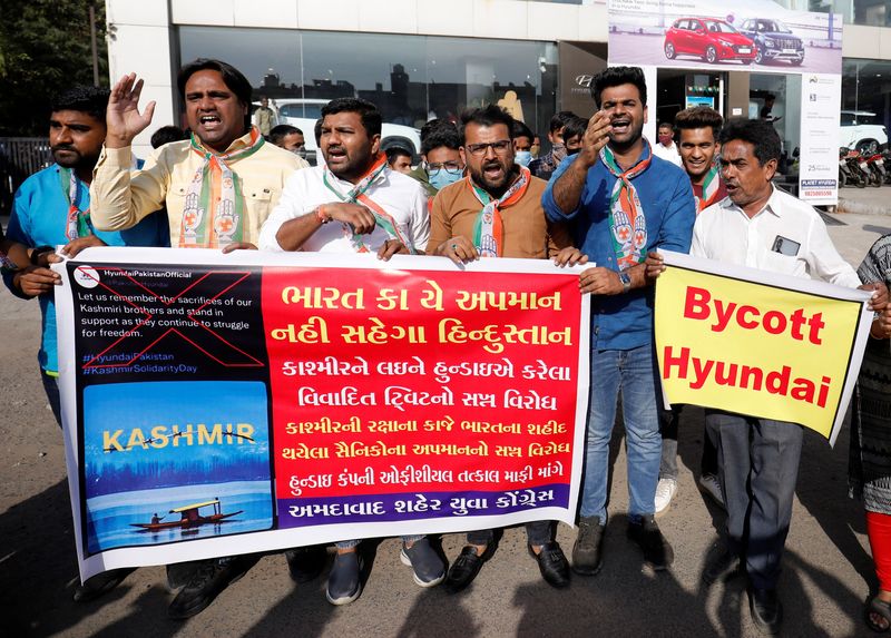 © Reuters. Supporters of the youth wing of India's main opposition Congress party shout slogans in front of a Hyundai showroom during a protest against a tweet from the account of Hyundai Pakistan partner that expressed solidarity for the people of Kashmir, in Ahmedabad, India, February 9, 2022. The placards reads: 