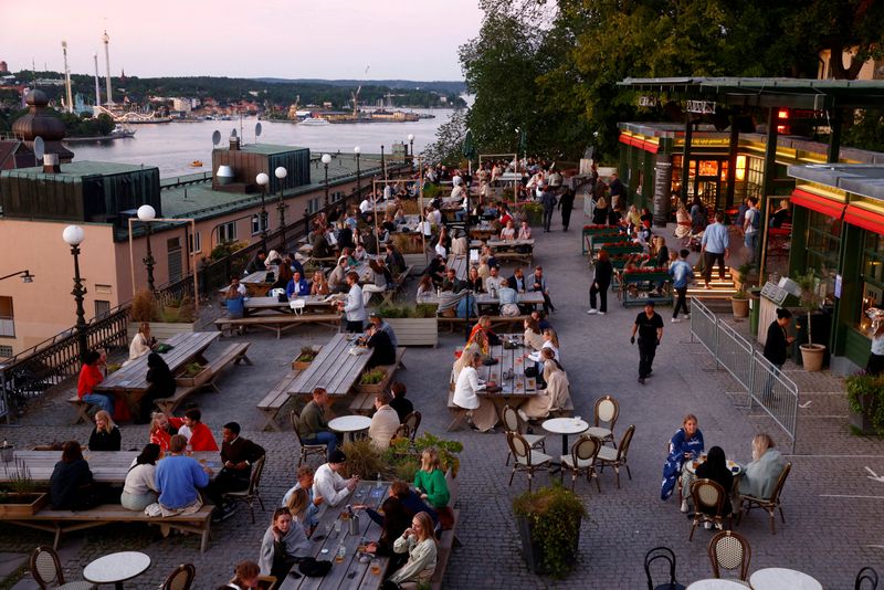 &copy; Reuters. FILE PHOTO: People sit at tables at an outdoor bar in Stockholm, Sweden,  July 1 2021. Stefan Jerrevang/TT News Agency/via REUTERS