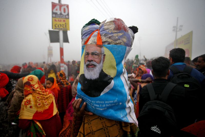 &copy; Reuters. A Hindu devotee carries her belongings in a bag with an image of India's Prime Minister Narendra Modi after taking a holy dip in the waters of Sangam, the confluence of the Ganges, Yamuna and Saraswati rivers to mark Mauni Amavasya, the most auspicious da