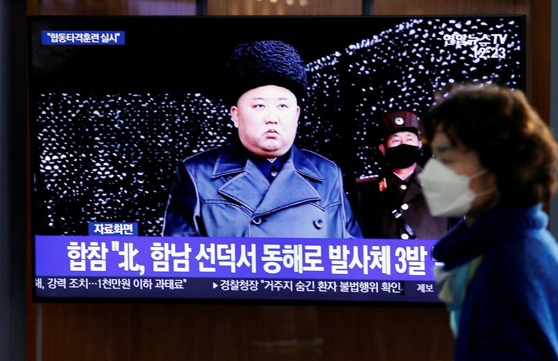 &copy; Reuters. FILE PHOTO: A woman walks past a TV broadcasting file footage for a news report on North Korea firing an unidentified projectile, in Seoul, South Korea, March 9, 2020.    REUTERS/Heo Ran/File Photo