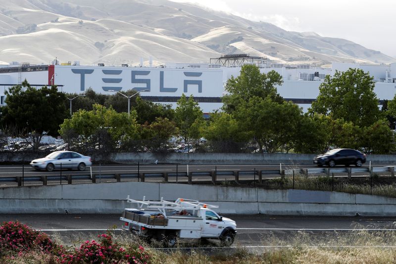 &copy; Reuters. FILE PHOTO - Motorists drive past Tesla's primary vehicle factory after CEO Elon Musk announced he was defying local officials' restrictions against the spread of the coronavirus disease (COVID-19) by reopening the plant in Fremont, California, U.S. May 1