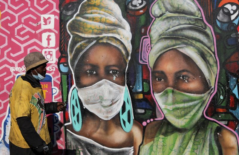 &copy; Reuters. FOTO DE ARCHIVO: Un hombre pasa frente a un mural que representa a dos mujeres con mascarilla en el barrio Kliptown de Soweto, Sudáfrica, el 1 de febrero de 2022. REUTERS/Siphiwe Sibeko 