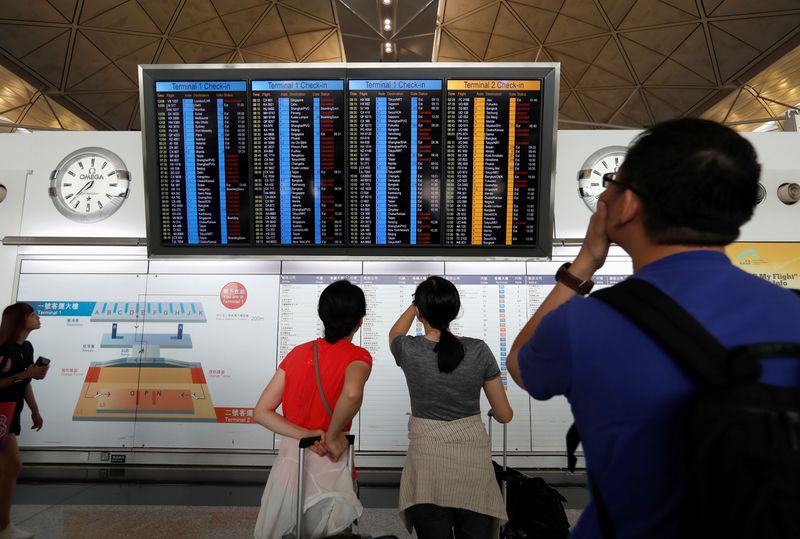 &copy; Reuters. Passengers react as they check the flight information board as the airport reopened a day after flights were halted due to a protest, at Hong Kong International Airport, China August 13, 2019. REUTERS/Issei Kato/Files