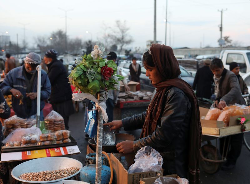 &copy; Reuters. FILE PHOTO: An Afghan salesman waits for customers in the center of Kabul, Afghanistan December 5, 2021. REUTERS/Ali Khara/File Photo