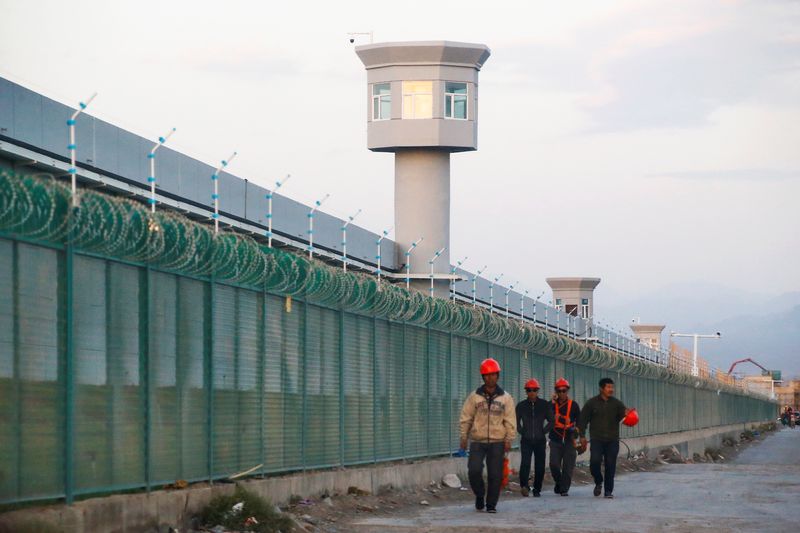 &copy; Reuters. FILE PHOTO: Workers walk by the perimeter fence of what is officially known as a vocational skills education centre in Dabancheng in Xinjiang Uighur Autonomous Region, China September 4, 2018. REUTERS/Thomas Peter/File Photo