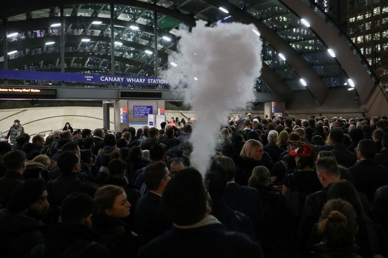 © Reuters. FILE PHOTO: A man smokes an e-cigarette in the queue to Canary Wharf tube station in London, Britain, November 27, 2019. Picture taken November 27, 2019. REUTERS/Kevin Coombs