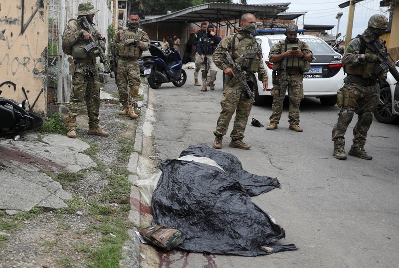 &copy; Reuters. Policiais perto de cadáver no chão durante operação policial no Complexo da Penha, no Rio de Janeiro
11/02/2022 REUTERS/Pilar Olivares