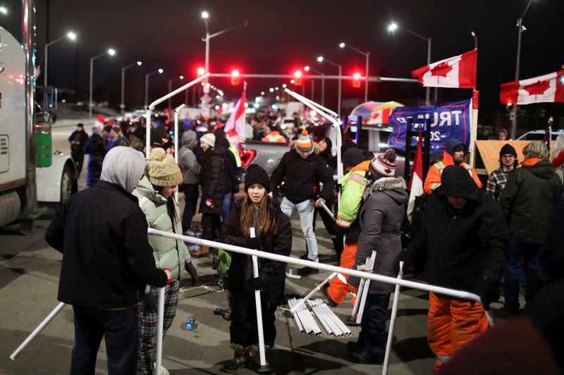 &copy; Reuters. Gente levanta una tienda de campaña mientras conductores de camiones y adherentes bloquean el acceso al Puente Ambassador, que une a Detroit y Windsor, en protesta contra las órdenes de vacunación contra el COVID-19, en Windsor, Ontario, Canadá. 10 de