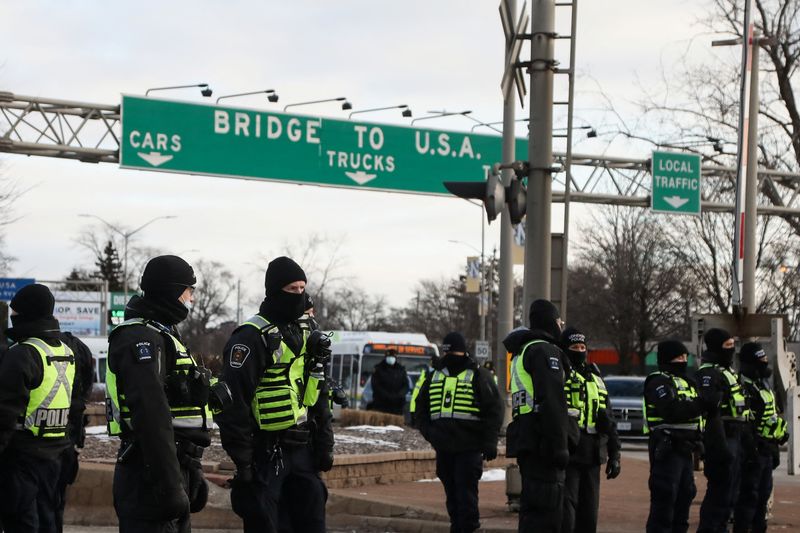 &copy; Reuters. أفراد من الشرطة يقفون على طريق فيما يواصل سائقو الشاحنات المحتجون على التطعيم الإلزامي ضد كوفيد جسر (أمباسادور بريدج) الذي يربط بين كندا وال
