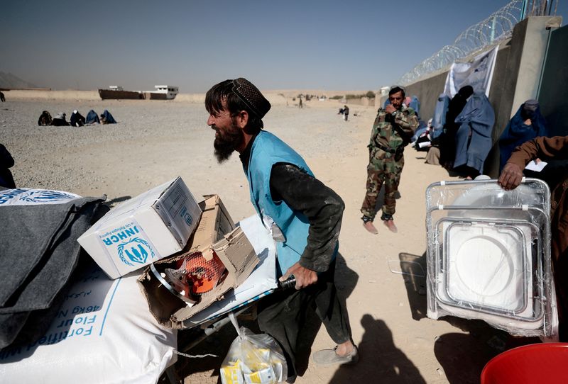 &copy; Reuters. موظف بمفوضية اللاجئين التابعة للأمم المتحدة يدفع بعربة عليها مساعدات خارج مركز لتوزيع المساعدات في العاصمة الأفغانية كابول يو 28 أكتوبر تشر
