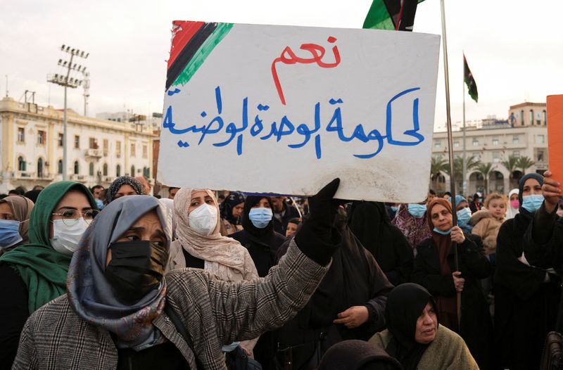 &copy; Reuters. امرأة ترفع لافتة تأييد للحكومة الليبية الموحدة في ساحة الشهداء في العاصمة الليبية طرابلس يوم 11 فبراير شباط 2022. تصوير: ندا حريب - رويترز.