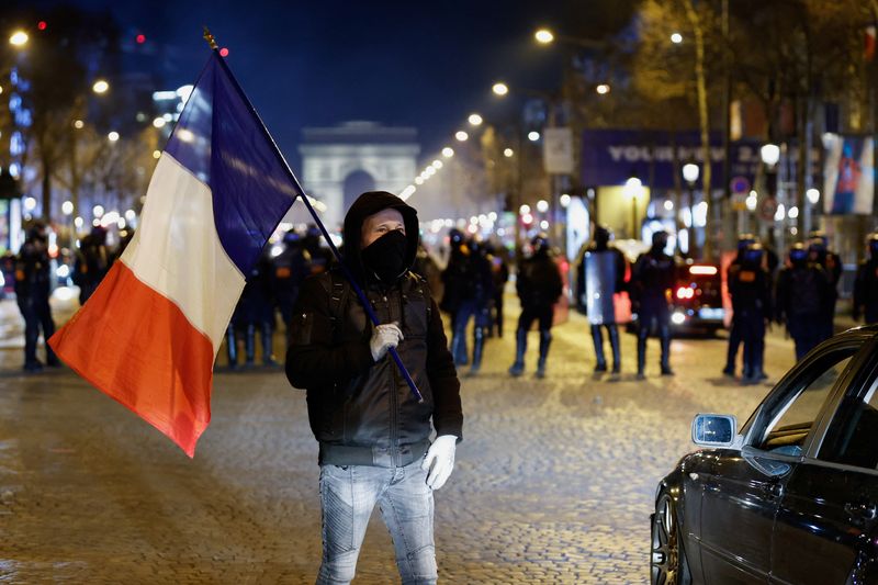 © Reuters. A protester waves a French flag on the Champs-Elysees avenue as cars try to block the traffic during their 