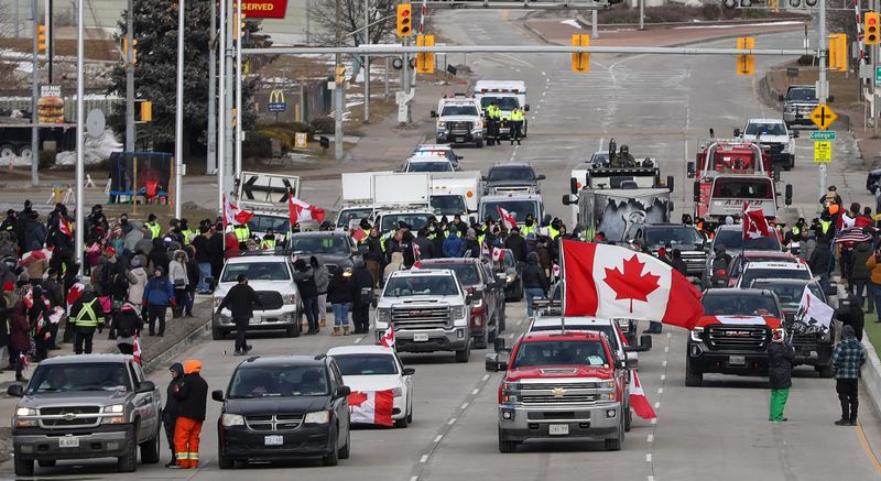 &copy; Reuters. 　カナダで新型コロナウイルスワクチン接種義務などに抗議するトラック運転手らが米国との国境の橋を封鎖し、主要な物流ルートが遮断されている問題で、デモ隊と警察の間では１２日も