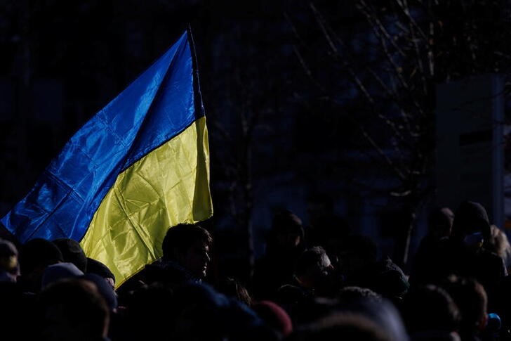 © Reuters. A person holding the Ukrainian flag takes part in a protest demanding new sanctions against Russia, during the visit of German Chancellor Olaf Scholz, in Kyiv, Ukraine, February 14, 2022. REUTERS/Antonio Bronic