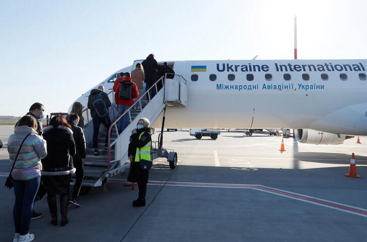 &copy; Reuters. Passengers board a plane during a tour to the Chernobyl exclusion zone at the Boryspil International Airport outside Kyiv, Ukraine April 3, 2021. Ukraine International Airlines made a special offer marking the 35th anniversary of the Chernobyl nuclear dis