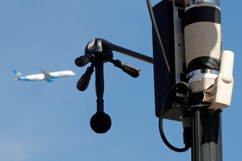 © Reuters. صورة من أرشيف رويترز لطائرة تحلق في السماء بينما يظهر رادار لرصد الأصوات المزعجة في بلدة فيلينوف لو روا بالقرب من مطار أورلي بباريس.