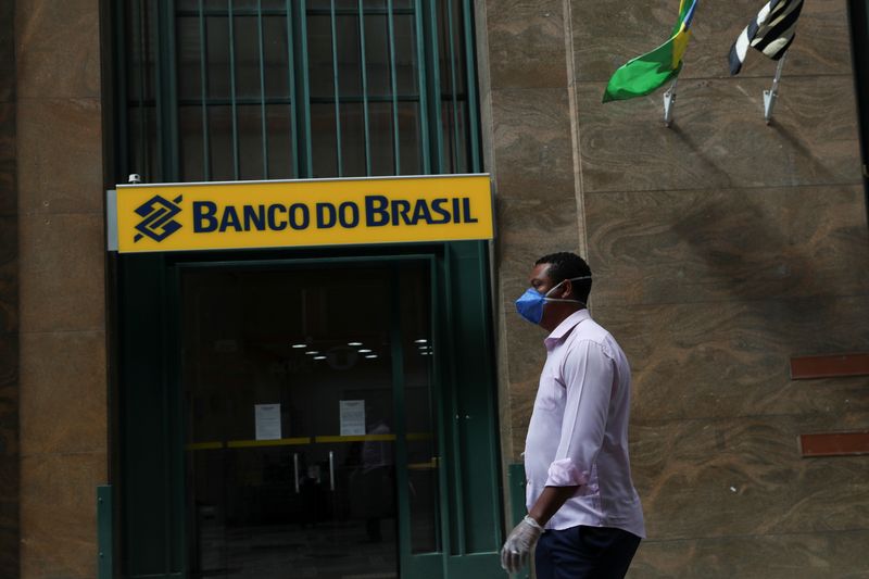 &copy; Reuters. FILE PHOTO: A man wearing a protective face mask and gloves walks in front of Banco do Brasil (Bank of Brazil) during the coronavirus disease (COVID-19) outbreak in Sao Paulo, Brazil, March 24, 2020. REUTERS/Amanda Perobelli