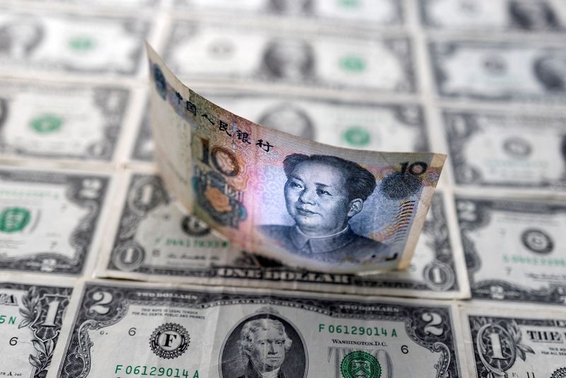 © Reuters. Chinese yuan banknote is displayed on U.S. Dollar banknotes in this illustration taken, February 14, 2022. REUTERS/Dado Ruvic/Illustration