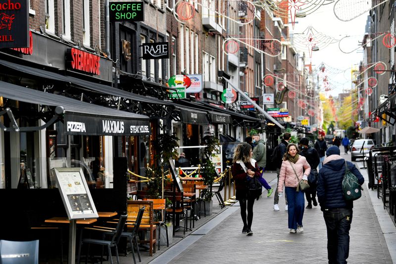 © Reuters. FILE PHOTO: People walk past restaurants and bars in Amsterdam, Netherlands October 14 2020. REUTERS/Piroschka van de Wouw/File Photo