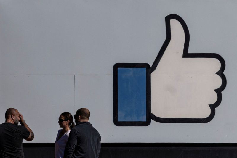 &copy; Reuters. FILE PHOTO: People stand in front of the entrance sign to Facebook headquarters in Menlo Park, California, U.S. October 27, 2021.  REUTERS/Carlos Barria/File Photo