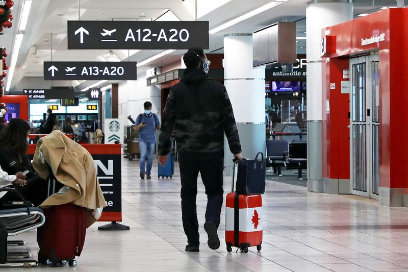 &copy; Reuters. FILE PHOTO: A United States-bound passenger walks in Toronto Pearson Airport's Terminal 3, days before new coronavirus disease (COVID-19) testing protocols to enter the U.S. come into effect, in Toronto, Ontario, Canada December 3, 2021.  REUTERS/Chris He