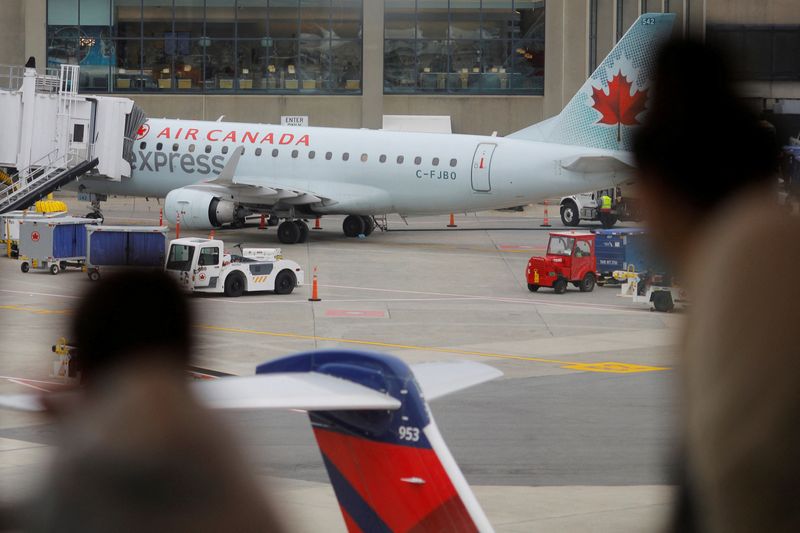 &copy; Reuters. FILE PHOTO: An Air Canada plane sits at a gate at Logan International Airport, amid cancellations and disruptions due to adverse weather and the surge in coronavirus cases caused by the Omicron variant, in Boston, Massachusetts, U.S., January 3, 2022.   R