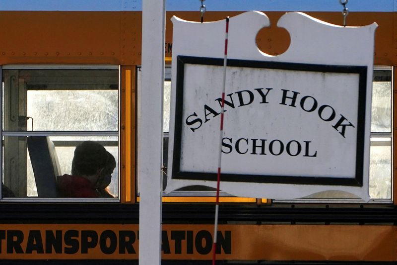 © Reuters. A school bus drives past a Sandy Hook school sign following a settlement with Remington Arms and the families of Sandy Hook victims in Newtown, Connecticut, U.S., February 15, 2022. REUTERS/Carlo Allegri