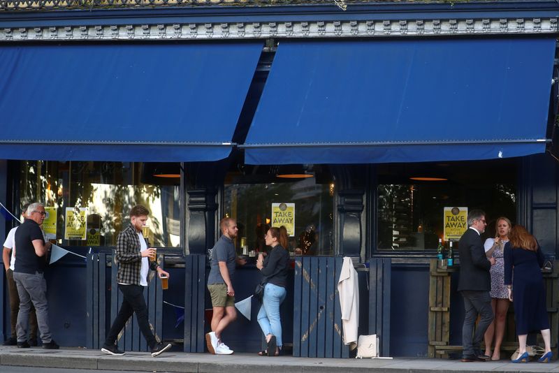 &copy; Reuters. FILE PHOTO: People drink alcohol outside a pub serving takeaway beer, in London, Britain June 18, 2020. REUTERS/Hannah McKay