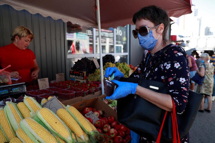 &copy; Reuters. A woman wearing a protective face mask and gloves amid the coronavirus disease (COVID-19) outbreak buys vegetables at a street market in Kyiv, Ukraine September 7, 2020. REUTERS/Valentyn Ogirenko