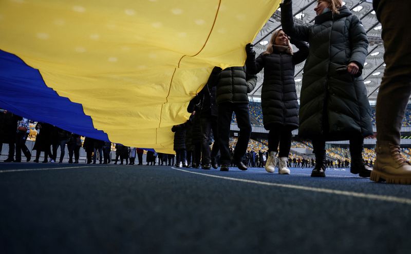 &copy; Reuters. مواطنون أوكرانيون يحملون العلم الوطني في استاد كييف الأولمبي احتفالا بيوم الوحدة في كييف يوم الأربعاء. تصوير: أوميت بيكتاس - رويترز.