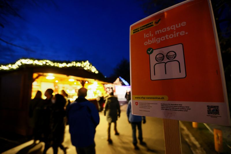 © Reuters. A sign indicating that masks are compulsory is placed at the Christmas Market, amid the coronavirus disease (COVID-19) pandemic, in Montreux, Switzerland December 6, 2021. REUTERS/Denis Balibouse/Files