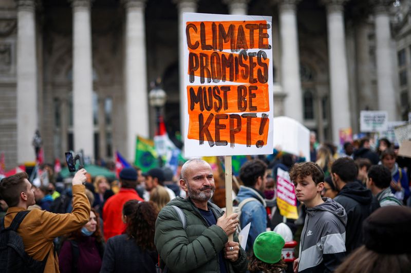 &copy; Reuters. FILE PHOTO: A demonstrator holds a banner during a protest outside the Bank of England, as the UN Climate Change Conference (COP26) takes place, in London, Britain, November 6, 2021. REUTERS/Henry Nicholls/File Photo