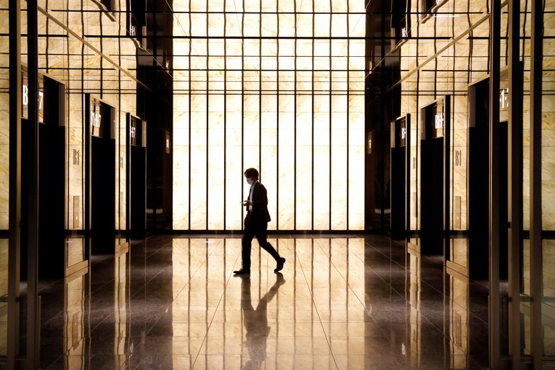 &copy; Reuters. A man wearing a protective face mask walks in an office building at a quiet business district on the first working day after the Golden Week holiday, following the coronavirus disease (COVID-19) outbreak, in Tokyo, Japan, May 7,2020.REUTERS/Kim Kyung-Hoon