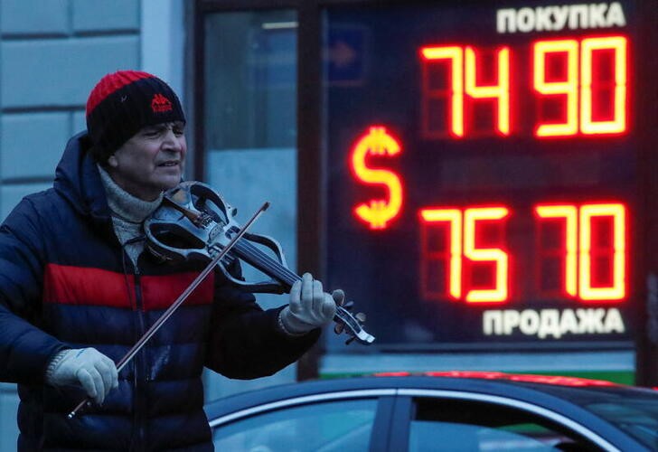 &copy; Reuters. A street performer plays the violin near a board showing currency exchange rates of U.S. dollar against the Russian rouble in Saint Petersburg, Russia February 16, 2022. REUTERS/Anton Vaganov