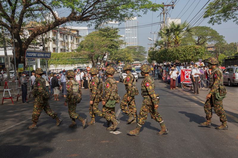 &copy; Reuters. جنود يعبرون الشارع بينما يحتشد الناس للاحتجاج على الانقلاب العسكري في ميانمار يوم 15 فبراير شباط 2022. تصوير: رويترز. 