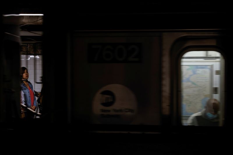 &copy; Reuters. A woman waits for a NYC subway, amid the coronavirus disease (COVID-19) pandemic, as a man wearing a protective face mask sits inside a passing train in New York City, U.S., October 20, 2021. REUTERS/Shannon Stapleton