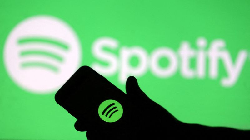 &copy; Reuters. FILE PHOTO: A smartphone is seen in front of a screen projection of Spotify logo, in this picture illustration taken April 1, 2018. REUTERS/Dado Ruvic/Illustration/File Photo