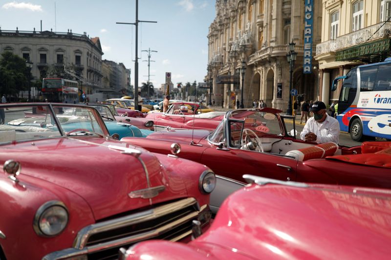 &copy; Reuters. Conductores de taxis esperan por turistas cerca de vehículos antiguos en La Habana, Cuba, Febrero 16, 2022.  REUTERS/Amanda Perobelli