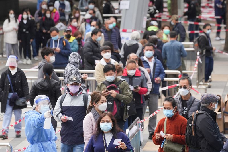 &copy; Reuters. FILE PHOTO: People wearing face masks queue at a makeshift testing centre for the coronavirus disease (COVID-19) following the outbreak, in Hong Kong, China February 18, 2022. REUTERS/Lam Yik