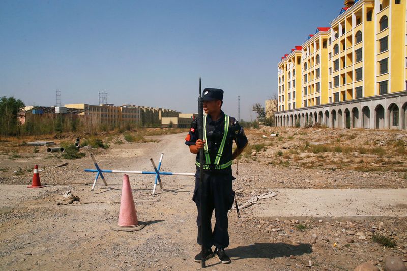 &copy; Reuters. FOTO DE ARCHIVO: Un funcionario de policía chino toma posición en la ruta cerca de un centro educacional en Yining, China, 4 de septiembre del 2018. /Thomas Peter