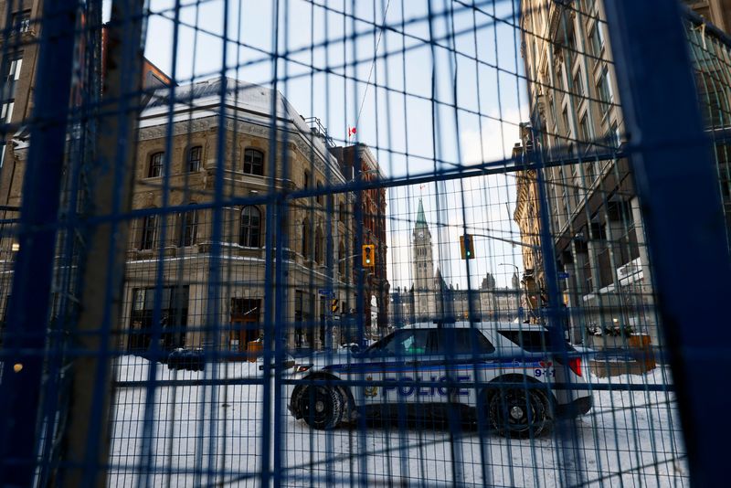 © Reuters. A police vehicle is seen behind fences as Canadian police officers work to restore normality to the capital while trucks and demonstrators continue to occupy the downtown core for more than three weeks to protest against pandemic restrictions in Ottawa, Ontario, Canada, February 19, 2022.  REUTERS/Blair Gable