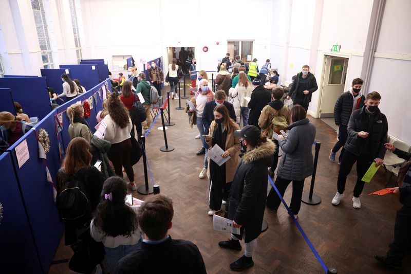 &copy; Reuters. FILE PHOTO: People queue at a coronavirus disease (COVID-19) vaccination centre in London, Britain, December 15, 2021. REUTERS/Hannah McKay