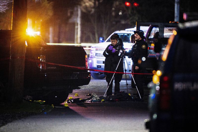 &copy; Reuters. FILE PHOTO: Police officers view the crime scene, where according to the Portland Police Bureau one person was shot dead and five others were wounded, at Normandale Park in Portland, Oregon, U.S. February 19, 2022. Picture taken February 19, 2022. REUTERS