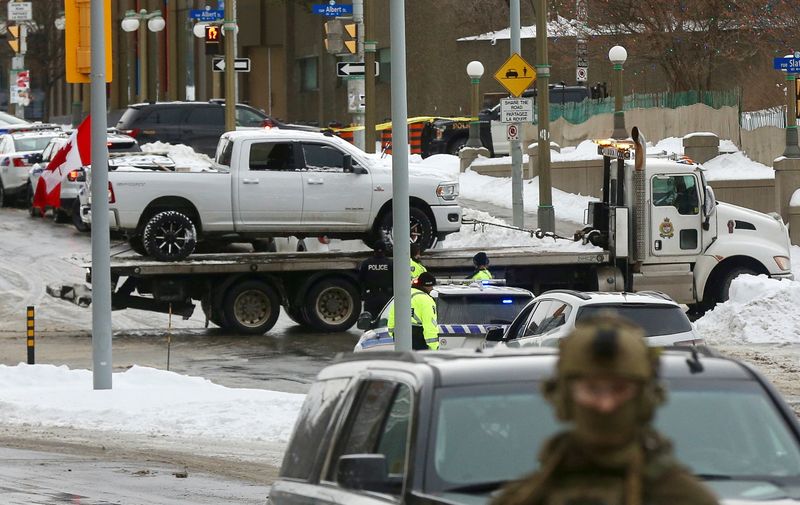 &copy; Reuters. حافلة عليها العلم الكندي يتم نقلها فيما يعمل رجال الشرطة الكندية على رفع احنات والأشخاص الذين احتلوا قلب المدينة لثلاثة أسابيع بعد احتجاج ل