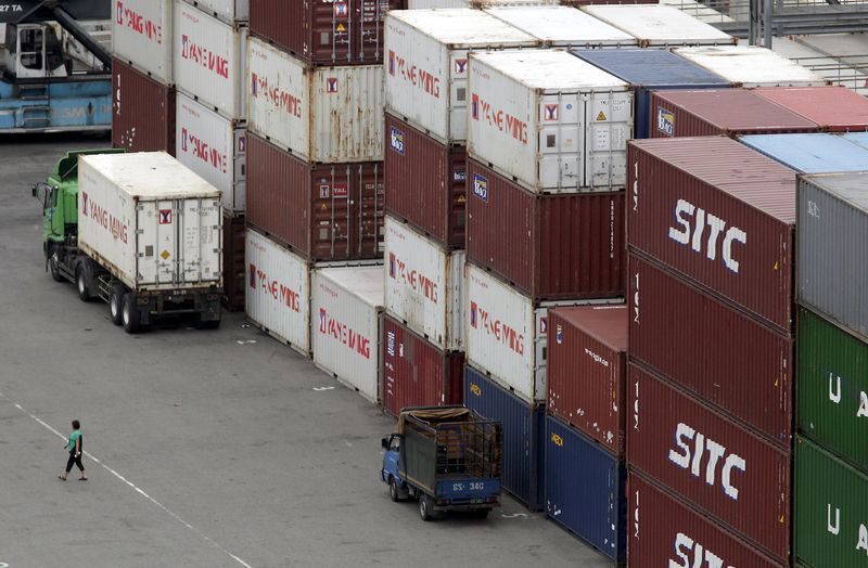 &copy; Reuters. FILE PHOTO: A person walks near containers at Keelung port, northern Taiwan, October 30, 2015. REUTERS/Pichi Chuang