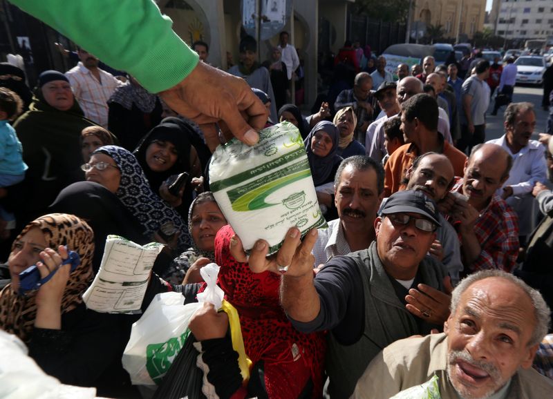 &copy; Reuters. بائع في شاحنة حكومية يقدم كيسا من السكر المدعم لأحد المشترين في القاهرة بصورة من أرشيف رويترز.