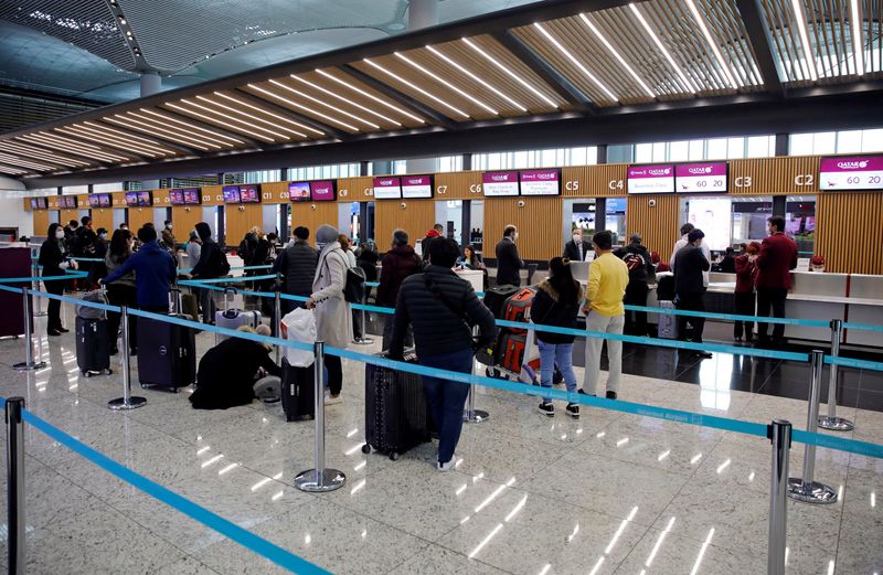 &copy; Reuters. FILE PHOTO: Passengers wearing protective face masks queue for a check-in, during the outbreak of the coronavirus disease (COVID-19), at Istanbul Airport, Turkey March 29, 2020. REUTERS/Umit Bektas