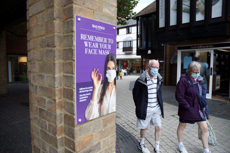 &copy; Reuters. Elders walk past a sign advising the use of face masks, amid the coronavirus disease (COVID-19) outbreak, in St Albans, Britain September 23, 2020. REUTERS/Peter Cziborra/Files