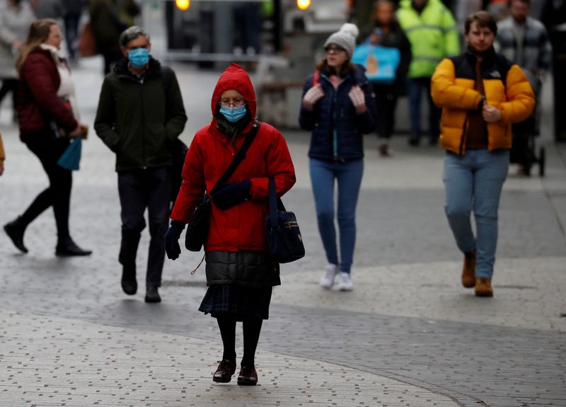 &copy; Reuters. FILE PHOTO: A woman wearing a face mask walks through the centre of Liverpool, Britain, November 29, 2021. REUTERS/Phil Noble